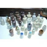 A large collection of various glass bottles, stoneware storage jars, etc.