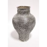 AN INDIAN SILVER VASE of ovoid form with narrow neck & foot, with all-over finely embossed &