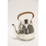 A George V tea kettle of plain rounded form with cane-bound overhang handle, 6¾" high, London