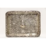 An Edwardian rectangular tray with raised sides, & all-over embossed scroll & flower decoration,