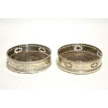 A PAIR OF GEORGE III WINE COASTERS, the pierced & engraved sides decorated with husk swags & oval