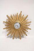 An early 20th century wall timepiece with 4” diam. silvered dial in giltwood sunburst case; 20”