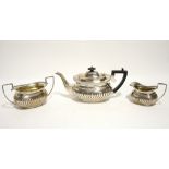 A late Victorian three-piece tea service of oblong semi-fluted design with gadrooned rims; the