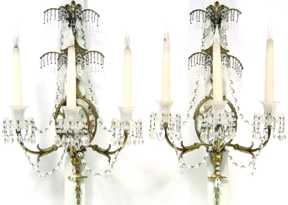 A PAIR OF GEORGE III STYLE ORMOLU WALL LIGHTS, each with oval mirror back-plate with segmented