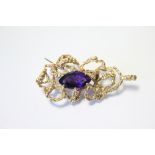 A 9ct gold brooch/pendant of open abstract form set navette-shaped amethyst, 2" wide. (12.3gm