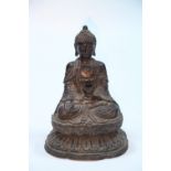 A large Chinese cast metal seated figure of the Buddha, on oval lotus flower base; 18” high.