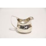 A George III cream jug of squat oval shape, with reeded rim & angular handle, 3" high; London