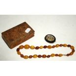 An amber bead necklace, 16" long (24.5g); and a mosaic oval bar brooch.