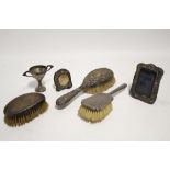 Two silver-backed hair brushes; a silver-backed clothes brush; a silver two-handled trophy cup; &