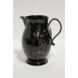 An 18th century Jackfield black-glazed pottery ovoid jug with strap handle & polychrome