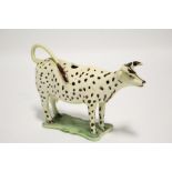 A late 18th century Whieldon-type creamware cow creamer with under-glaze brown dot decoration, on