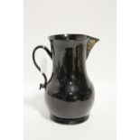 An 18th century Jackfield black-glazed pottery large baluster jug with strap handle, & traces of