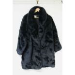A simulated black fur ladies’ three-quarter length coat; a gent’s three-quarter length coat; &