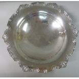 A silver cake dish, having a shell and s