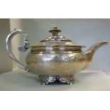 A George III silver teapot of circular,