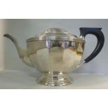 A silver teapot of multi-panelled, oval