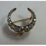 A gold coloured metal crescent brooch, c