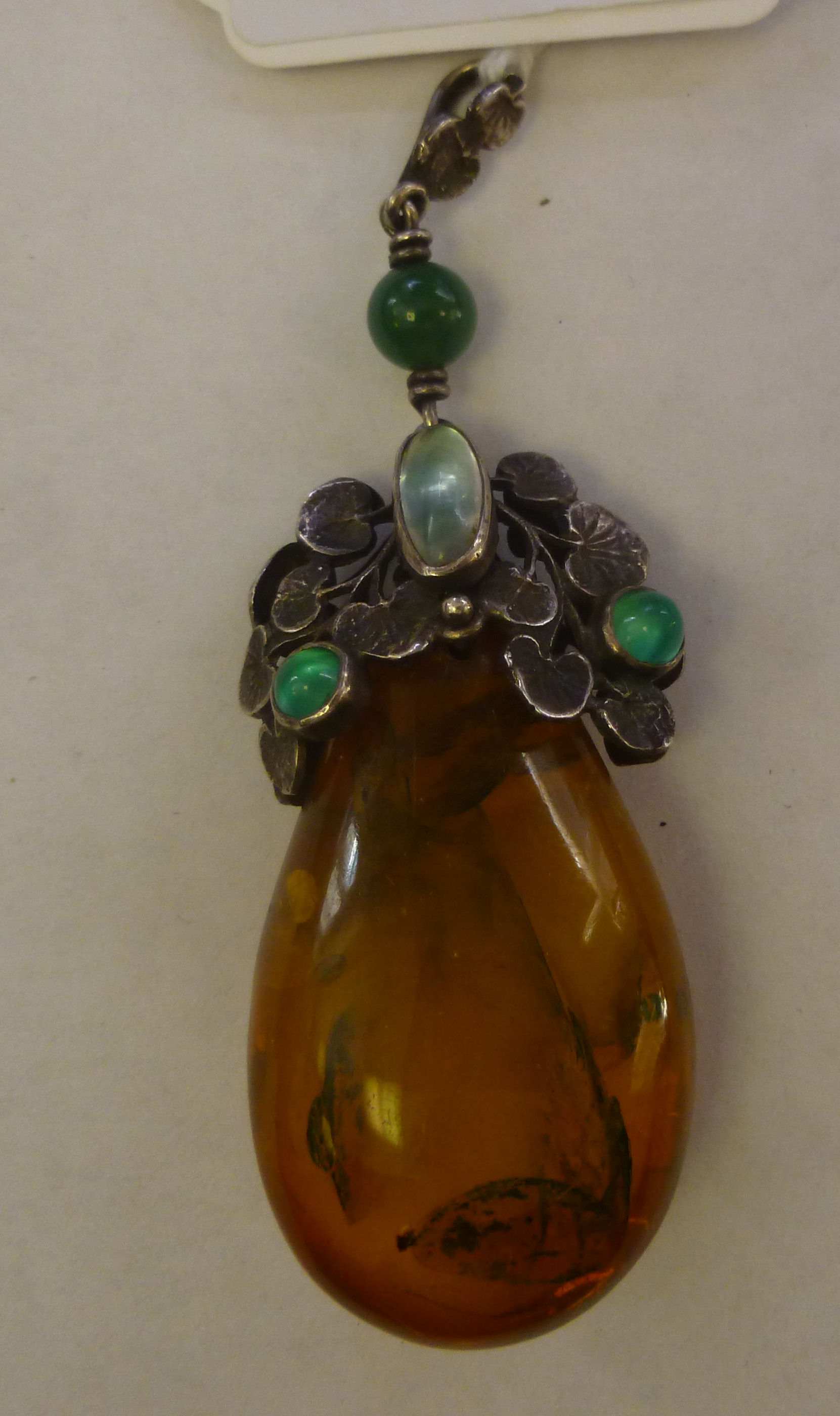 An amber coloured peardrop pendant, on a