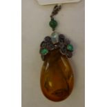 An amber coloured peardrop pendant, on a