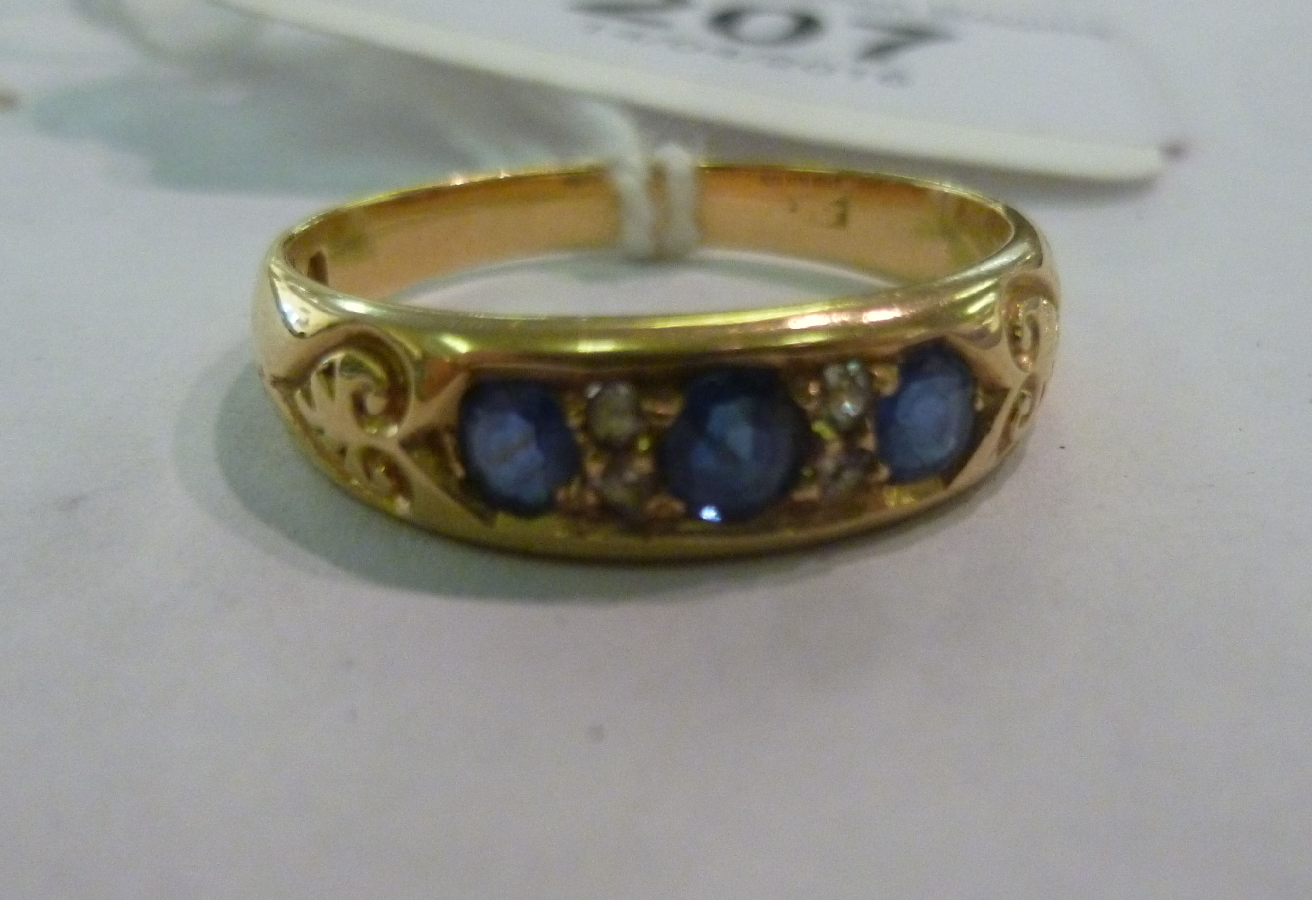 An 18ct gold ring, three sapphires inter