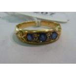 An 18ct gold ring, three sapphires inter