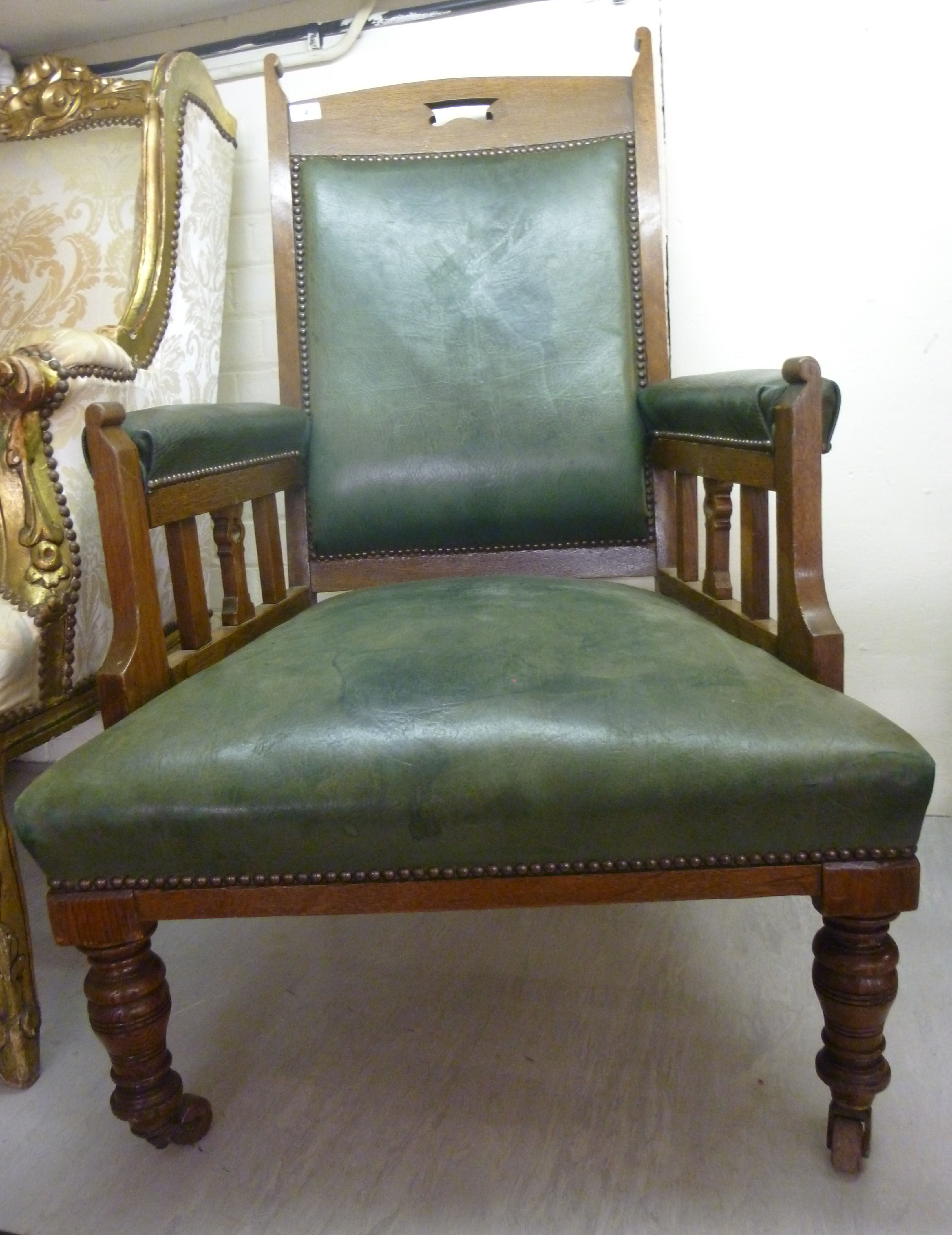 An early 20thC oak framed open arm chair