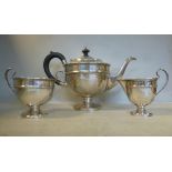 A three piece silver tea set of pedestal