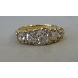 A gold coloured metal five stone diamond