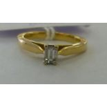 An 18ct gold single baguette cut diamond