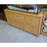 A modern pale oak seven drawer dressing