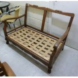 A 1930s oak settee frame, having a carve