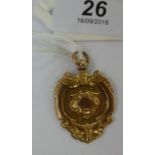 A 9ct gold, scrolled pendant medallion w