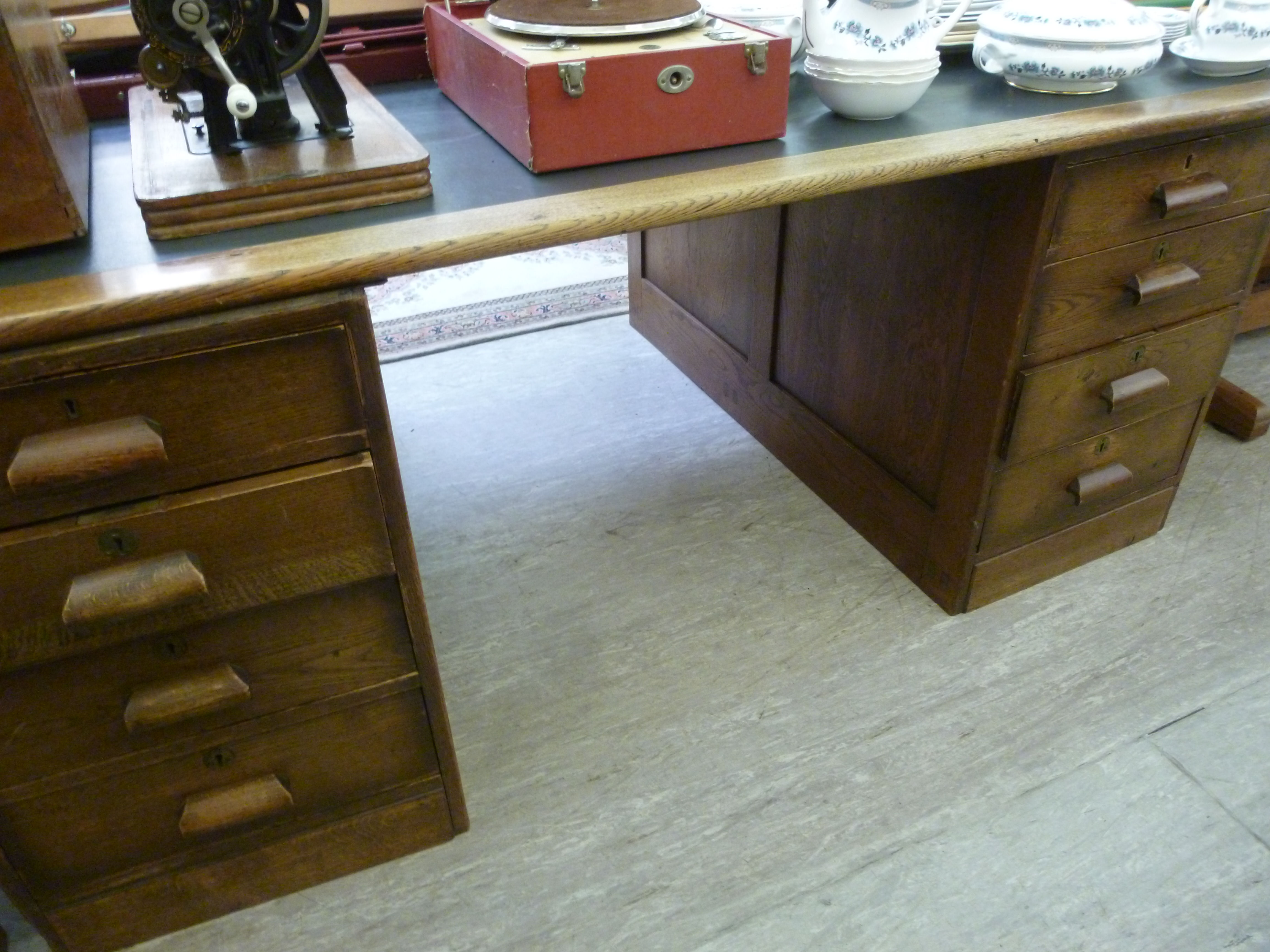 A 1920s oak partners' desk of panelled d