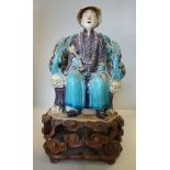 A 20thC Chinese porcelain figure, a seated man, his throne like chair adorned with dragons 9.