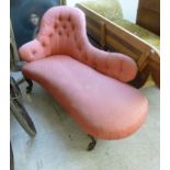 A late Victorian carved walnut framed spoonback daybed, upholstered in part buttoned pink fabric,