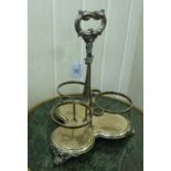 A late Victorian/Edwardian silver plated triform tantalus with a central foliate handle and three