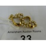 A gold coloured metal ribbon scrolled and diamond set pendant 11