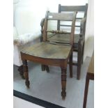 An early 19thC elm open arm chair with a bar back and a solid seat, raised on square,
