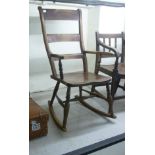 A late Victorian beech and satinwood bar back rocking chair with open arms,