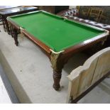 An early 20thC mahogany framed snooker/dining table with a green baize top, raised on ring turned,