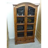 A modern Indonesian hardwood cabinet, having an arched top,