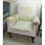 A late Victorian arm chair upholstered in calico, raised on bulbous, turned,