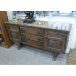 A modern stained oak sideboard with three central drawers, flanked by a pair of panelled doors,