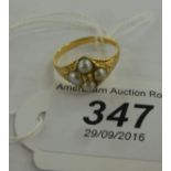 A gold coloured metal ring, set with a central diamond,
