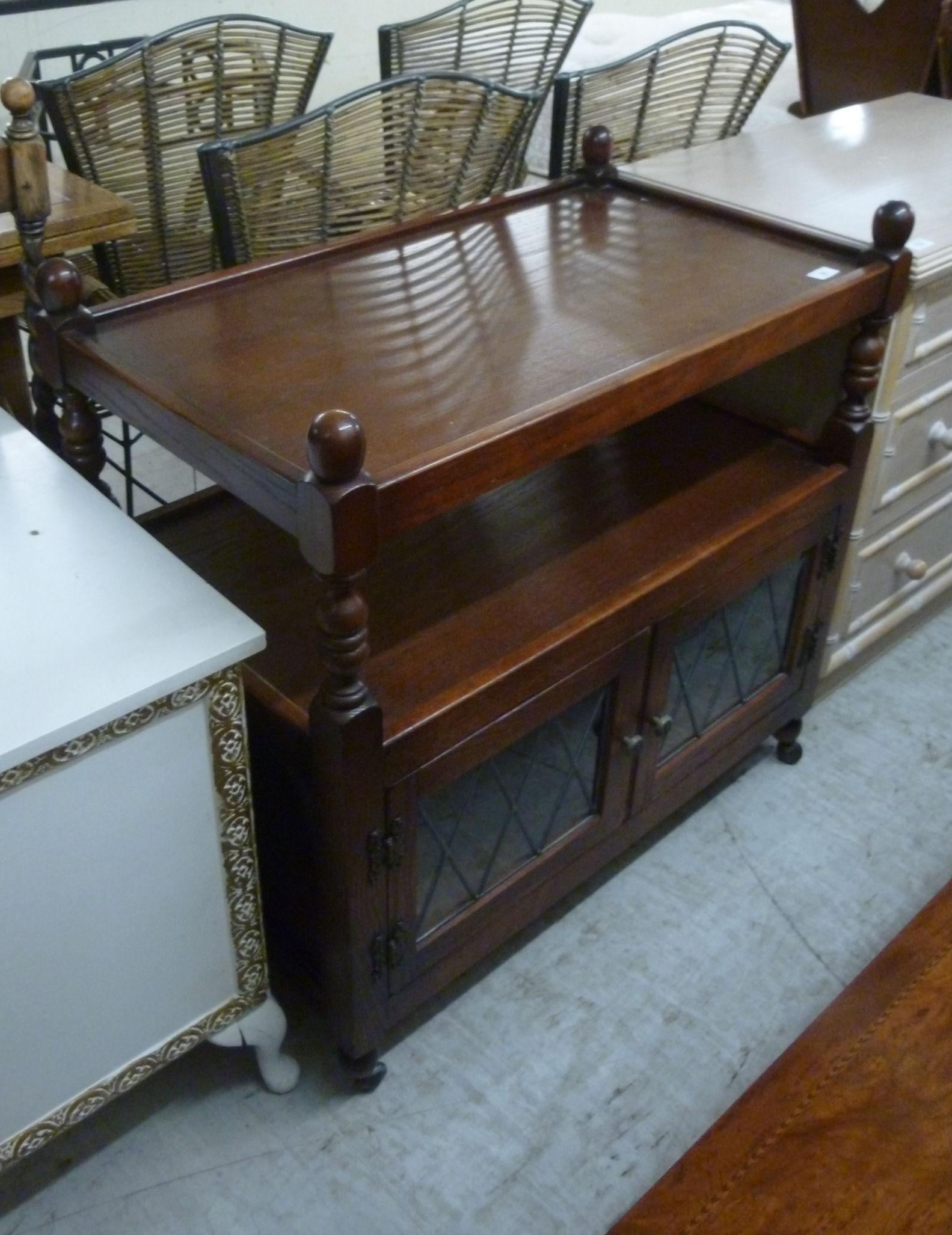 A modern oak finished tea trolley with two shelves, over a pair of lead glazed doors,