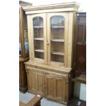 A late 19thC stained pine cabinet bookcase with a moulded cornice,