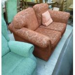 A modern two person settee, upholstered in red fleur de lys and floral design fabric,