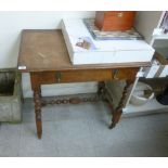 A 1920s oak single drawer side table, raised on ring turned,