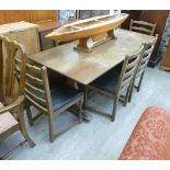 A modern stained oak Old English style refectory table, raised on carved ends,