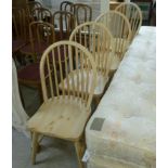 A set of four lime washed pine Windsor kitchen chairs, the solid seats raised on turned,